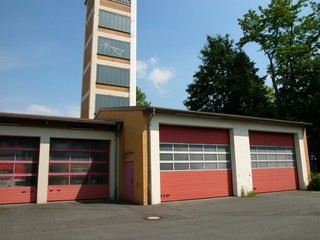 Feuerwehrstation in Lage im Kreis Lippe mit roten Toren und traditionellem Schlauchturm mit Fenster