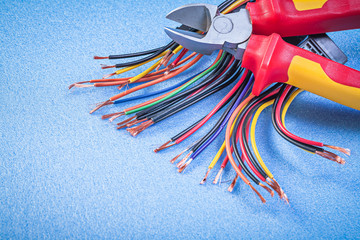 Electrical wires nippers on blue background electricity concept