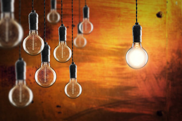 Idea and leadership concept -  bulbs on the grunge background