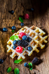 Fresh waffels with berry fruits on wooden bark