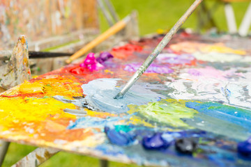Obraz premium Tiny paintbrush mixing colors outdoors
