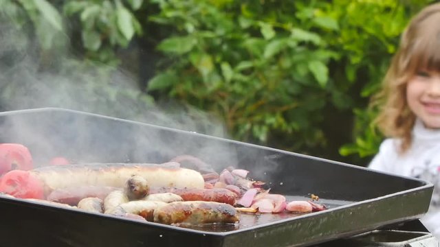 enfant regardant la cuisson &agrave; la plancha