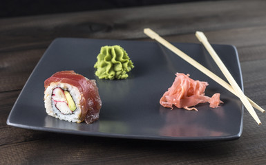Sushi. Red Spider Roll with pickled ginger and wasabi served on grey plate.