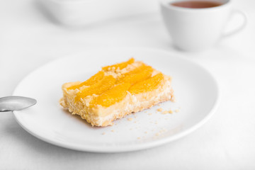 Pie with oranges in the baking dish on a white table
