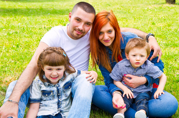 Fototapeta premium Family Lying On Grass In Park Together
