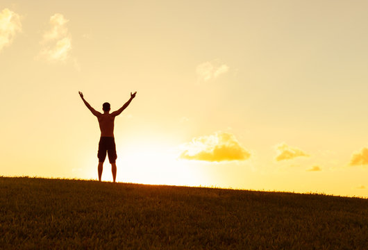 Young man with arms up in the air feeling happy and free. 