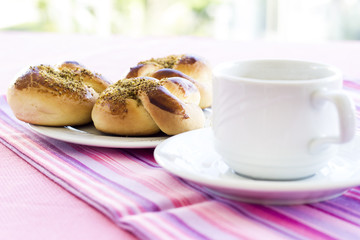Croissant and pastry cup of coffee on the pink cloth at breakfast