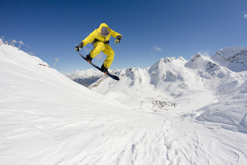 Snowboard rider jumping on mountains. Extreme snowboard freeride sport.