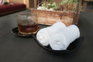 white scented rolled wet towel and cold drink to welcome a guest to Thai aroma massage resort spa, Thailand.
