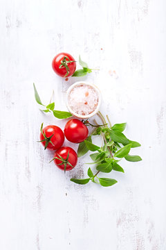 An arrangement of tomatoes, basil and himalayan salt