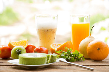 Background fruit have tomato and orange and juice with green tea cake.On wooden background outdoor view and holiday with relax 