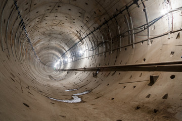 direct subway tunnel with a circular section and rails goes straight into the distance.
