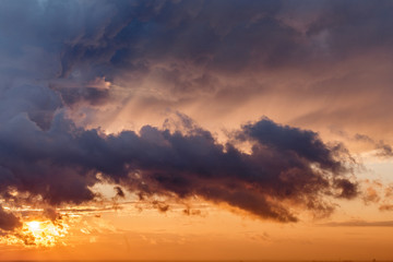 the sun shines through the clouds at sunset.