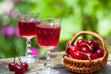 Cherry brandy and ripe berries on wooden table