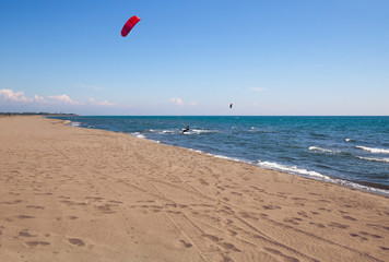 Athletic man riding on kite surf board on a sea waves