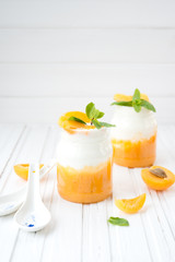 Natural yogurt in a jar with fresh apricots
