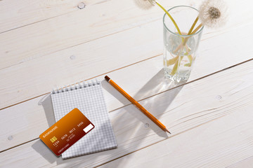 Pencil, notebook and credit card on the table