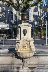 old water fountain with greek roman face at faucet