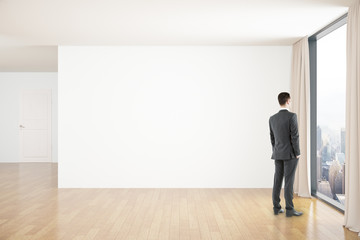 Businessman in room with blank wall