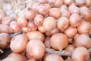 Sacs containing onion stacked for sale at farm market. 