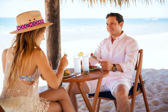 Man eating lunch with his date at the beach