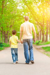 Obraz premium Cheerful boy and grandparent walking in the nature