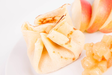 Pancake sack stuffed with braised apples decorated with apple slices
