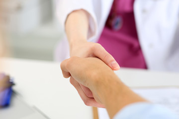 Female medicine doctor shake hand as hello with male patient