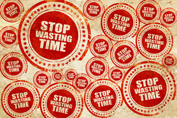 stop wasting time, red stamp on a grunge paper texture