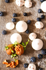 Obraz na płótnie Canvas meringue pavlova cake with fresh blueberries and walnuts on dark