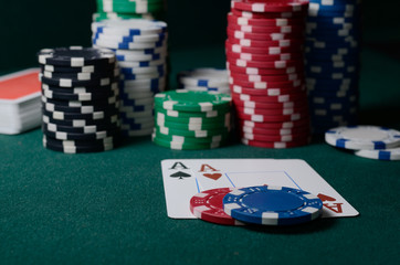 Casino chips and pair of aces on the green table. Poker game