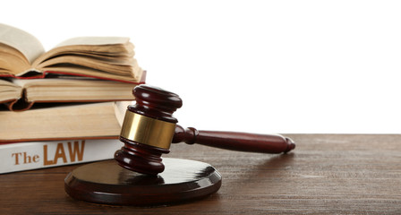 Gavel and books on wooden table on white background