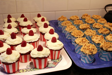 red raspberry and peanut brittle birthday cupcakes on trays 