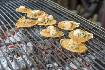 Baked scallops with butter and soy sauce in natural scallop shell delicious Thai seafood.