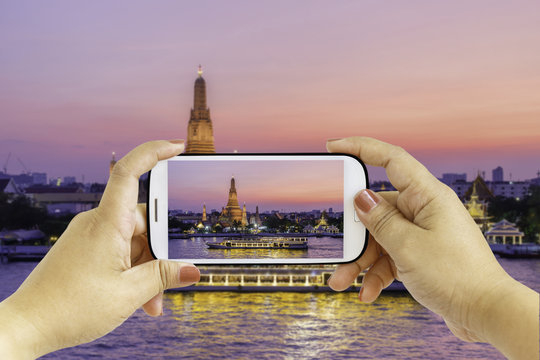Smartphone photographing Wat Arun Buddhist religious places in twilight time, Bangkok, Thailand