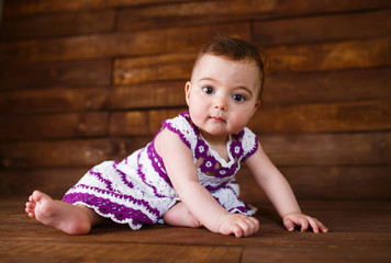 Cute little girl on a wooden background.