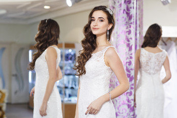 Fototapeta premium Female trying on wedding dress in a shop.