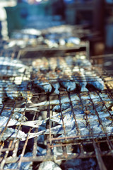 Top view on grilling fish on barbecue, background outdoors 