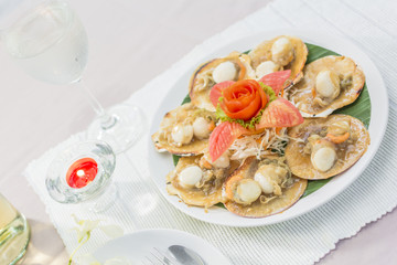 Baked scallops with butter and soy sauce in natural scallop shell delicious Thai seafood.