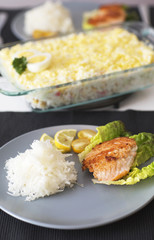 Fish atlantic salmon with salad and grated radish. The main meal for dinner with fish on the blue plate.
