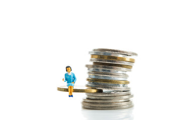 ミニチュア,お金の上に座って考えている女性