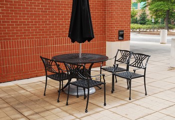 Fototapeta na wymiar patio furniture, chair, table and umbrella outside office building