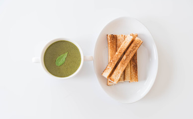 Fototapeta na wymiar Spinach soup with spinach leaves and bread
