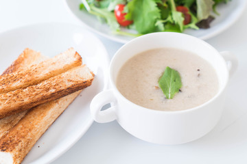 mushroom soup and bread in white ceramic cup