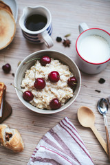 rich breakfast of porridge with cherries and pastry