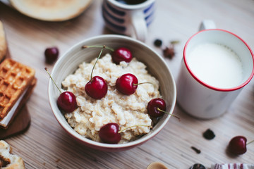 rich breakfast of porridge with cherries and pastry