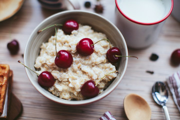rich breakfast of porridge with cherries and pastry