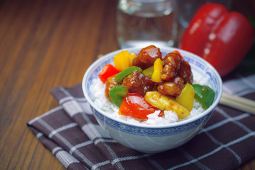 sweet and sour pork with rice. deep fried crispy pork stir fried with pineapple and fresh capsicum, in sour and sweet sauce on white rice. worldwide famous sweet and sour pork. chinese cuisine.