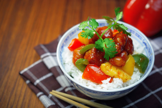 sweet and sour pork with rice. deep fried crispy pork stir fried with pineapple and fresh capsicum, in sour and sweet sauce on white rice. worldwide famous sweet and sour pork. chinese cuisine.