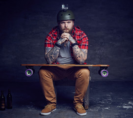 Male in red shirt posing with longboard in studio.
